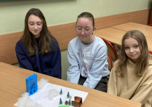 Uczennice klasy piątej prezentują makietę przedstawiającą świat Narnii z charakterystycznymi budowlami i zimową scenerią.