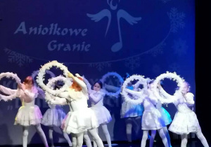Dziewczynki z klasy 2b wykonują taniec z białymi obręczami podczas koncertu Aniołkowe Granie.