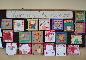 Tablica w świetlicy z wystawą kolorowych prac plastycznych z sercami i napisem „Kochanej Babci”.