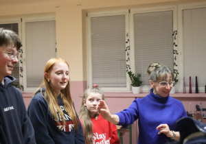 Nauczycielka muzyki prowadzi zajęcia pokazowe dla grupy dzieci w klasie.