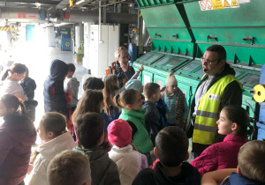 Uczniowie klasy 2b słuchają pracownika Zakładu Energetyki Cieplnej wyjaśniającego działanie urządzeń w hali ciepłowni.