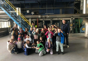 Uczniowie klasy 2b podczas wizyty w Zakładzie Energetyki Cieplnej w Pabianicach – zdjęcie grupowe w hali z instalacjami ciepłowniczymi.