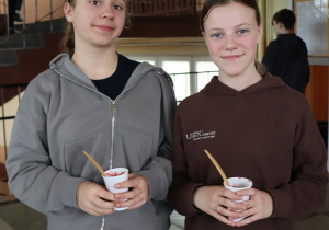 Uczennice prezentują zdrowe przekąski podczas kiermaszu zorganizowanego w ramach Tygodnia Zdrowego Odżywiania.