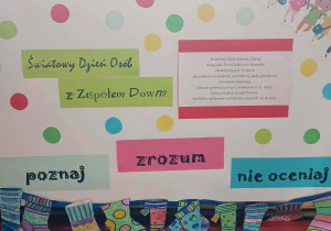 Kolorowy plakat z hasłami o akceptacji i integracji oraz oznaczeniem klasy, ozdobiony rysunkami skarpetek.