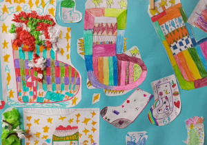 Plakat z rysunkami kolorowych skarpetek wykonanych przez uczniów z oznaczeniem klasy.