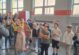 Uczniowie klasy 2B słuchają pracownika MZK. Jeden z chłopców zgłasza się do odpowiedzi. W tle widoczni nauczyciele Monika Juran-Tłoczek i Monika Mettler.