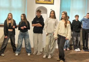 Uczniowie klasy 7a stoją w muzealnej sali i uważnie oglądają wystawę Kislinga w Pabianicach.