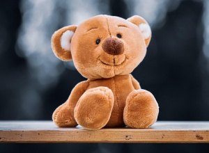 Pluszowy miś siedzący na ławce