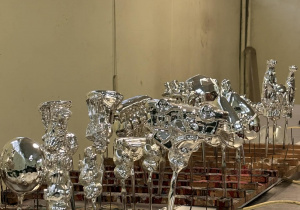 Świeżo posrebrzone szklane bombki w różnych kształtach stoją na stojakach do suszenia w fabryce.