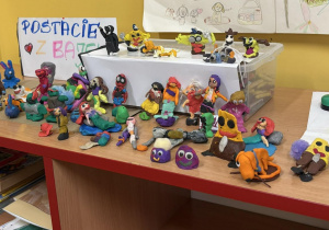 Wystawa plastelinowych „Postaci z bajek” w świetlicy szkolnej – na półce stoją różnorodne, kolorowe figurki wykonane przez dzieci z okazji Światowego Dnia Postaci z Bajek.
