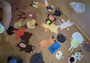 Stół w świetlicy pokryty kolorowymi papierowymi misiami i zwierzątkami – prace plastyczne wykonane przez uczniów w ramach listopadowych zajęć.