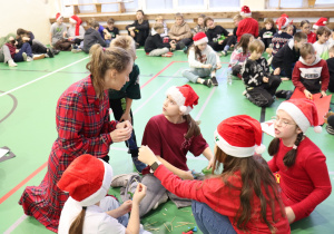 Nauczycielka SP 13 pomaga uczniom w pracy plastycznej podczas Mikołajek.