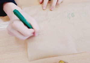 Uczeń szkicuje wzór pieczątki podczas lekcji „Kamieni na szaniec”.